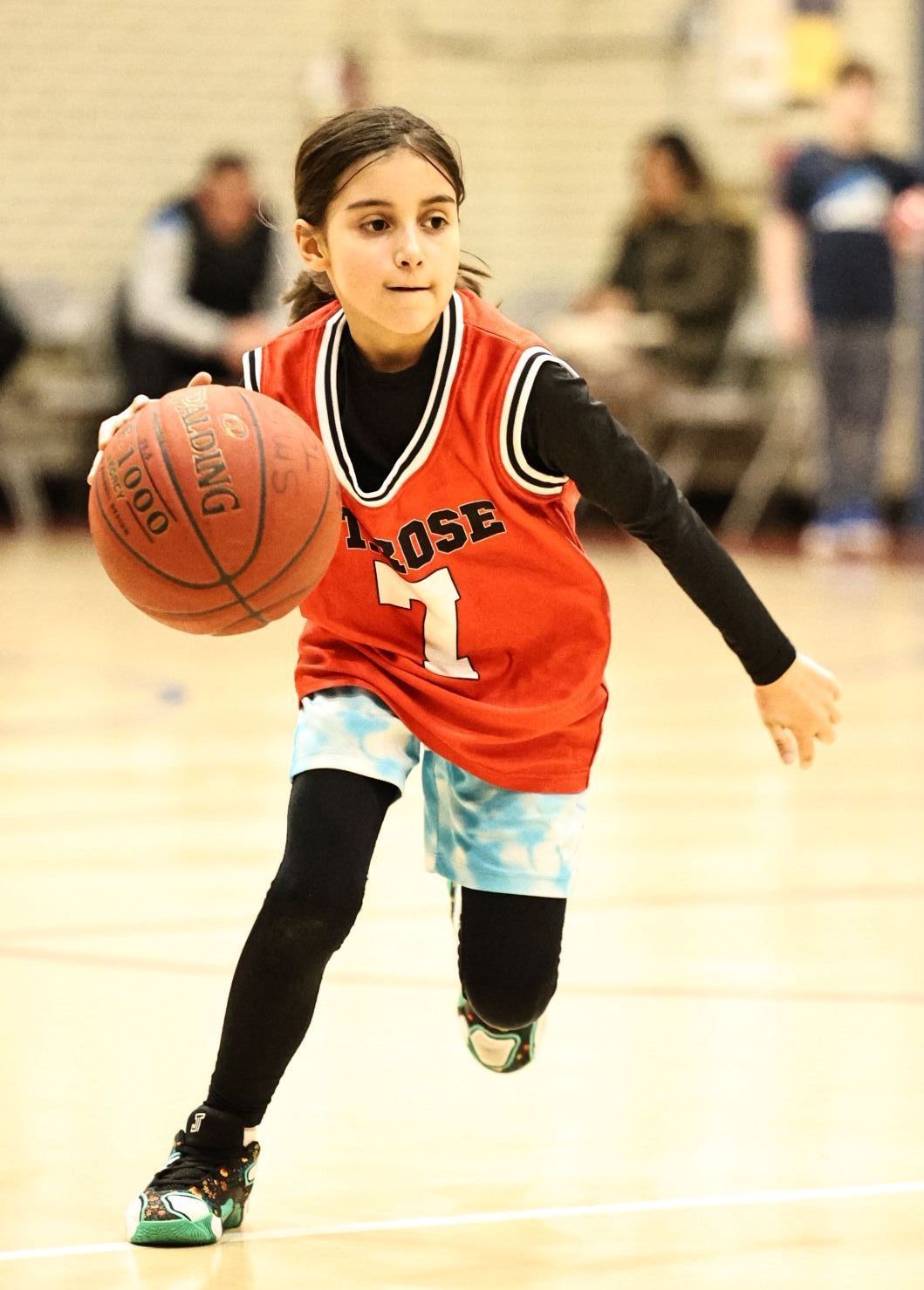 A girl in a 7 jersey dribbles the ball