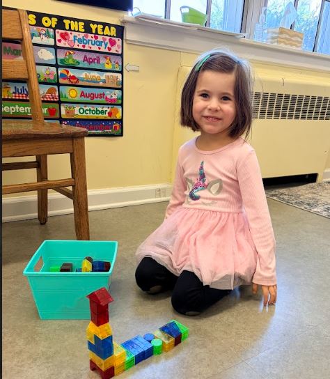 Preschool girl plays with magetic blocks 